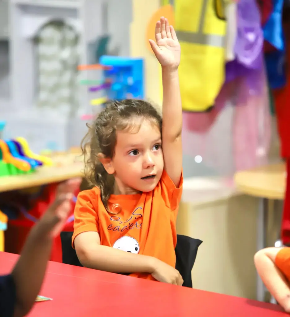 Preschool girl raising her hand in class at Bethany Christian Preschool in West Melbourne FL
